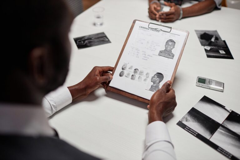 Close up of detective holding suspect personal file investigating criminal case